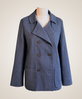 A blue pinstriped double-breasted blazer jacket displayed on a mannequin torso against a light beige background.