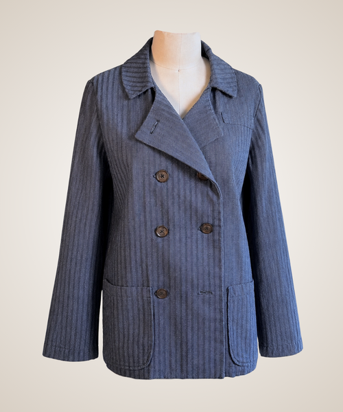 A blue pinstriped double-breasted blazer jacket displayed on a mannequin torso against a light beige background.
