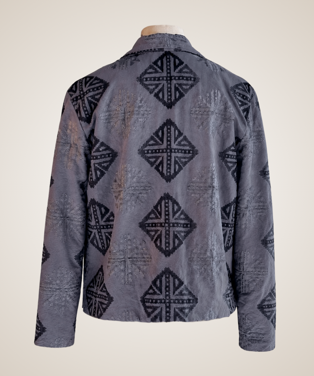 A gray long-sleeve button-up shirt jacket with a black geometric diamond pattern, displayed on a mannequin torso against a light beige background.