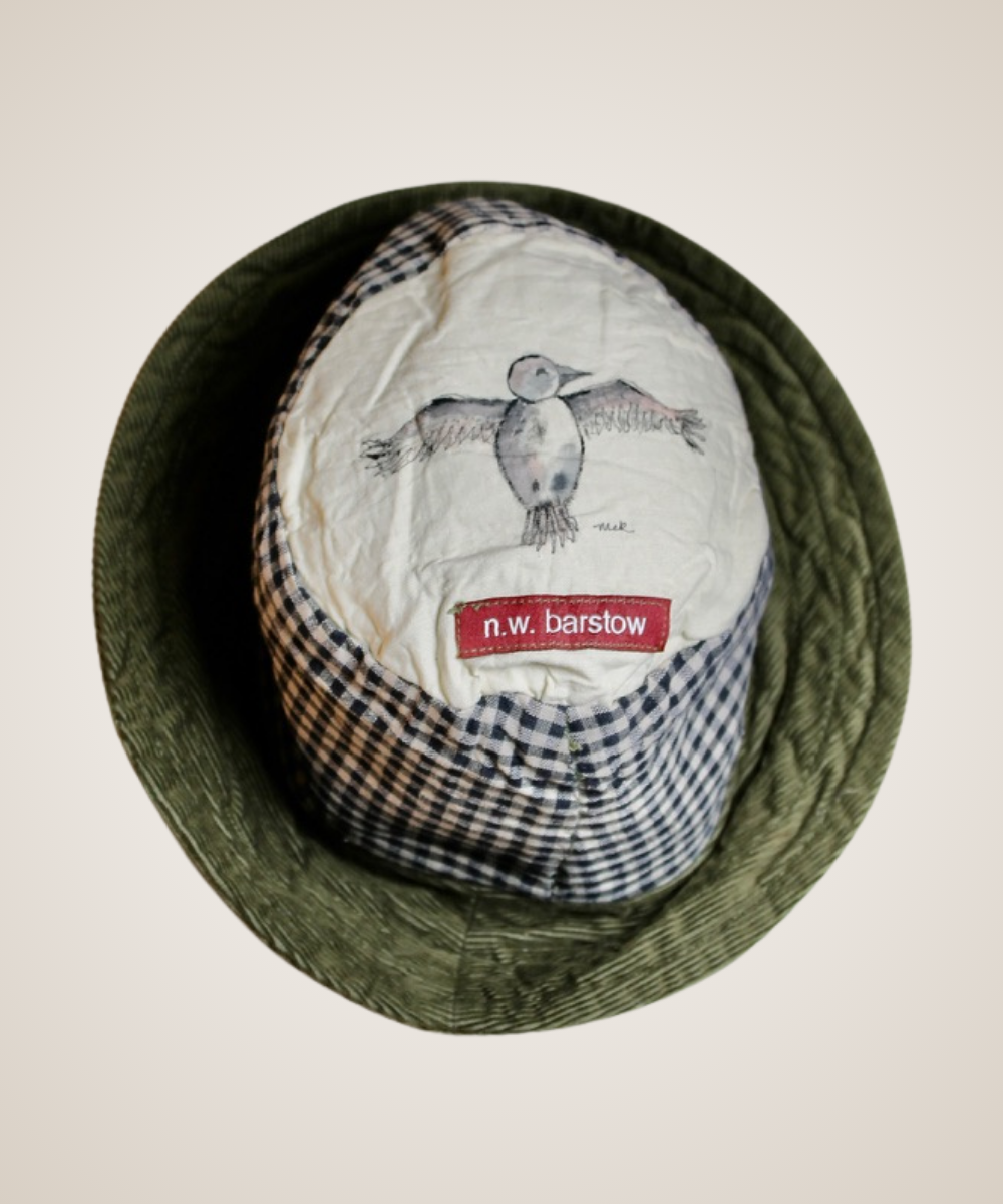 A striped knit cap with a blue and beige pattern, displayed on a beige fabric mannequin head against a light beige background.