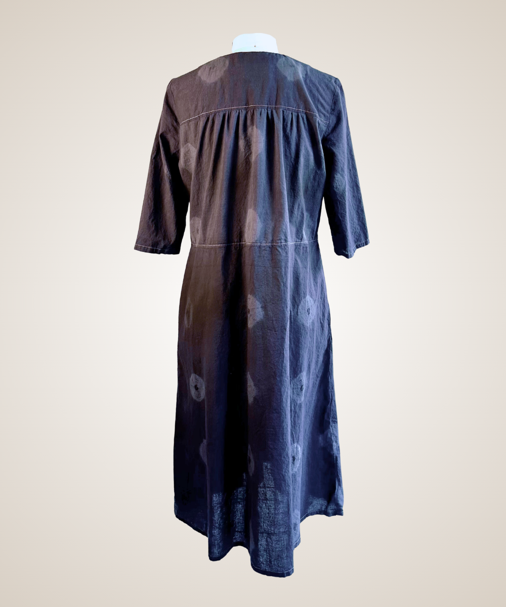 A close-up of a gray patterned button-up shirt jacket displayed on a dress form mannequin. The fabric features a textured, woven geometric tribal pattern in shades of gray and black, with three gold-tone buttons down the front.